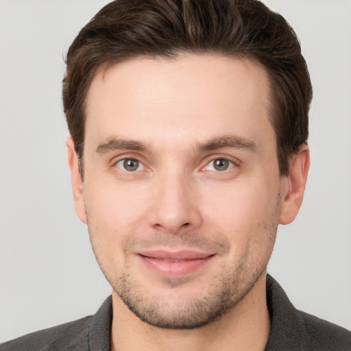 Joyful white young-adult male with short  brown hair and brown eyes