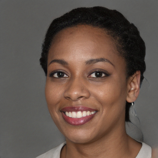 Joyful black young-adult female with short  black hair and brown eyes