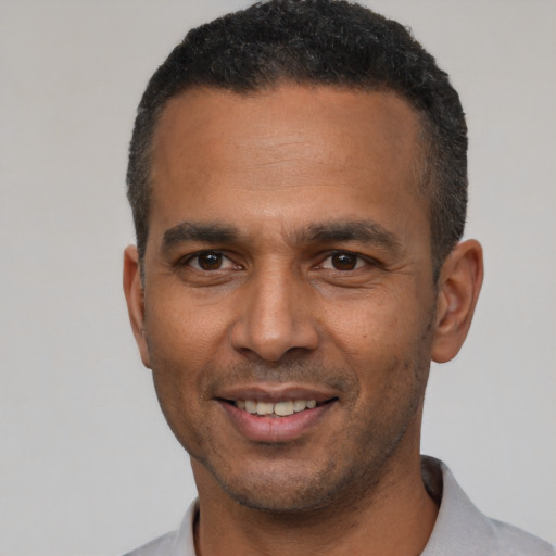 Joyful latino adult male with short  black hair and brown eyes