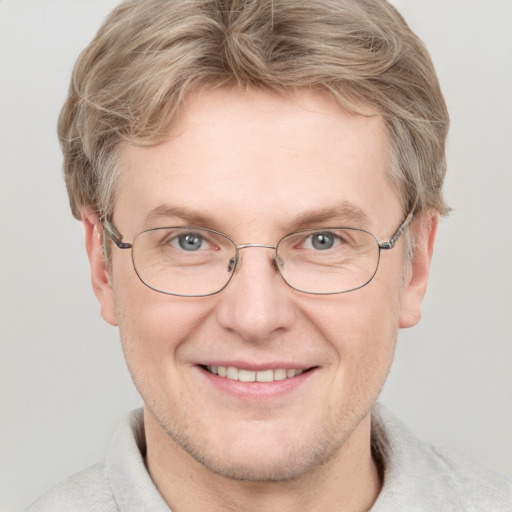 Joyful white adult male with short  brown hair and blue eyes