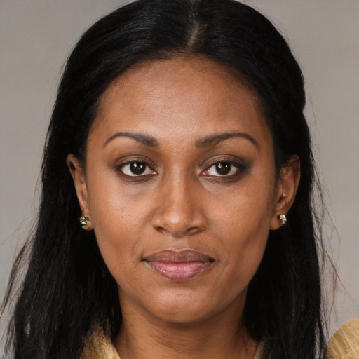 Joyful black young-adult female with long  brown hair and brown eyes
