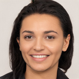 Joyful white young-adult female with long  brown hair and brown eyes