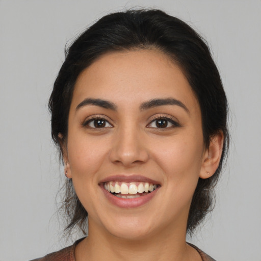 Joyful latino young-adult female with medium  brown hair and brown eyes