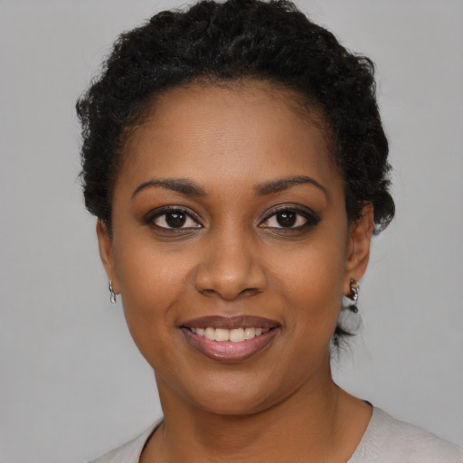 Joyful black young-adult female with short  brown hair and brown eyes