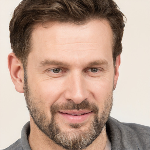 Joyful white adult male with short  brown hair and grey eyes