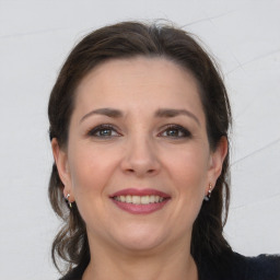 Joyful white adult female with long  brown hair and grey eyes