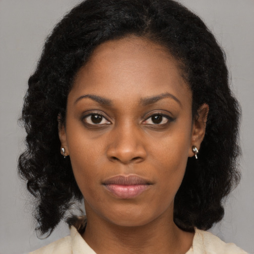Joyful black young-adult female with long  black hair and brown eyes