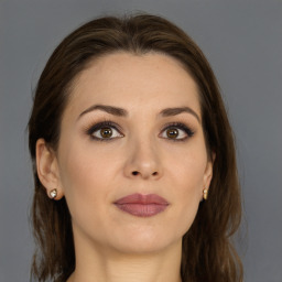 Joyful white young-adult female with long  brown hair and grey eyes