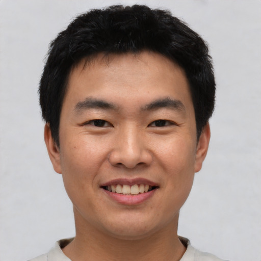 Joyful asian young-adult male with short  black hair and brown eyes