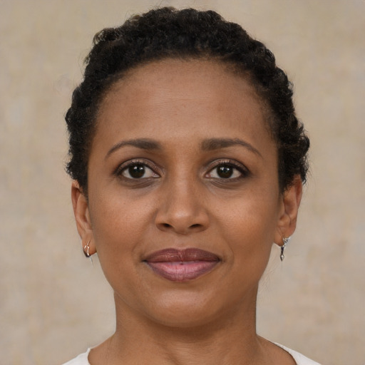 Joyful black young-adult female with short  brown hair and brown eyes