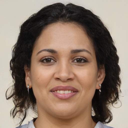 Joyful latino adult female with medium  brown hair and brown eyes