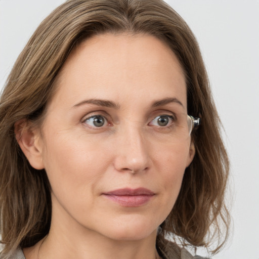 Joyful white adult female with medium  brown hair and grey eyes