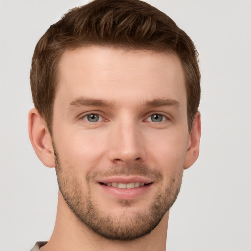 Joyful white young-adult male with short  brown hair and grey eyes