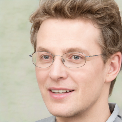 Joyful white adult male with short  brown hair and blue eyes