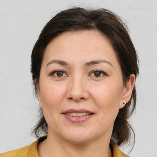 Joyful white adult female with medium  brown hair and brown eyes