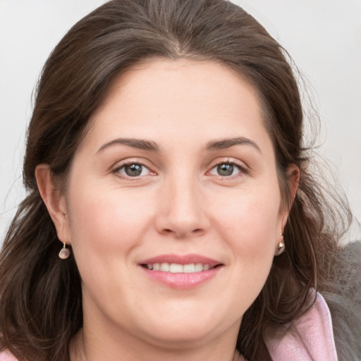 Joyful white young-adult female with medium  brown hair and grey eyes