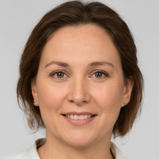 Joyful white adult female with medium  brown hair and brown eyes