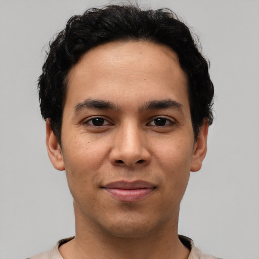 Joyful latino young-adult male with short  black hair and brown eyes