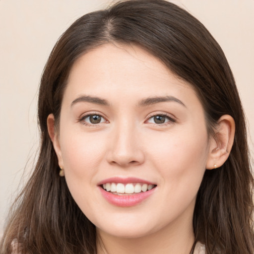 Joyful white young-adult female with long  brown hair and brown eyes