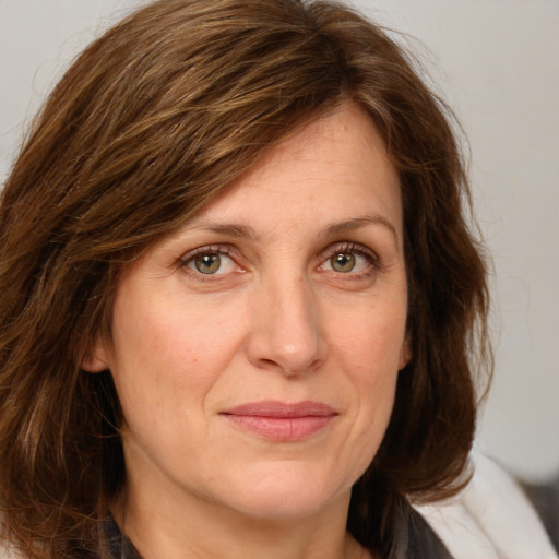 Joyful white adult female with medium  brown hair and green eyes