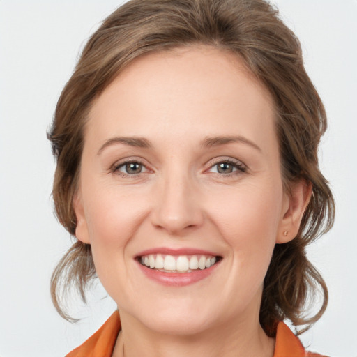 Joyful white young-adult female with medium  brown hair and grey eyes