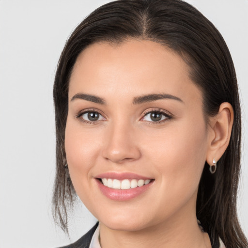 Joyful white young-adult female with long  brown hair and brown eyes