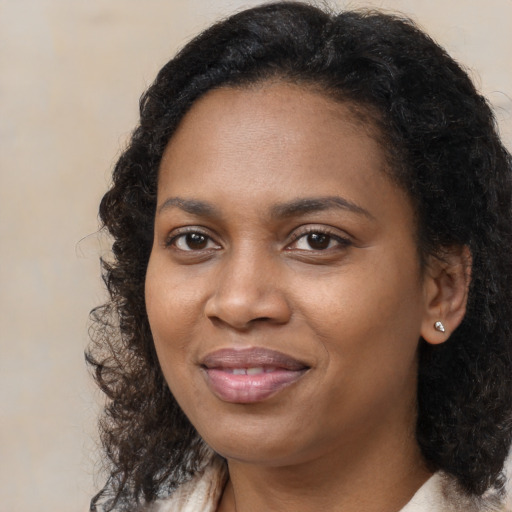 Joyful black young-adult female with long  brown hair and brown eyes