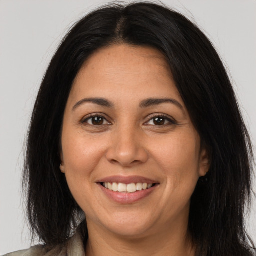 Joyful latino young-adult female with long  brown hair and brown eyes