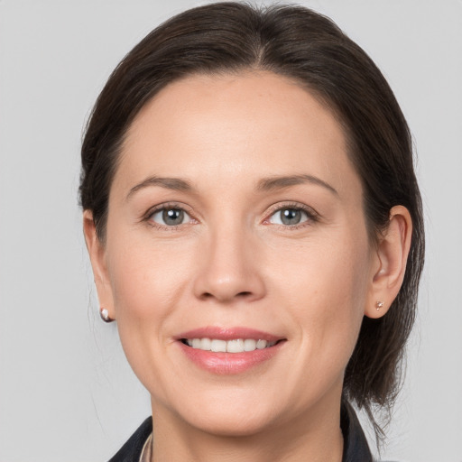 Joyful white adult female with medium  brown hair and grey eyes