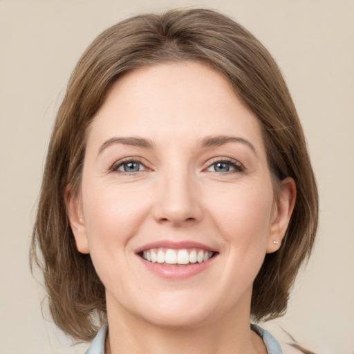 Joyful white young-adult female with medium  brown hair and grey eyes