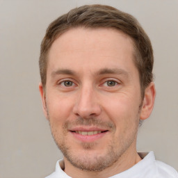 Joyful white young-adult male with short  brown hair and grey eyes