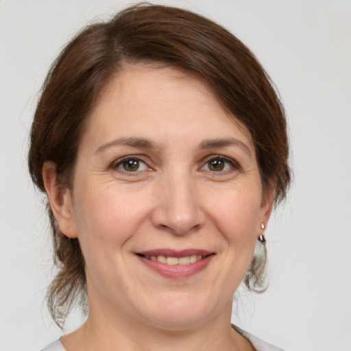 Joyful white adult female with medium  brown hair and grey eyes