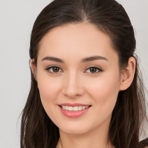 Joyful white young-adult female with long  brown hair and brown eyes