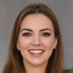 Joyful white young-adult female with long  brown hair and green eyes