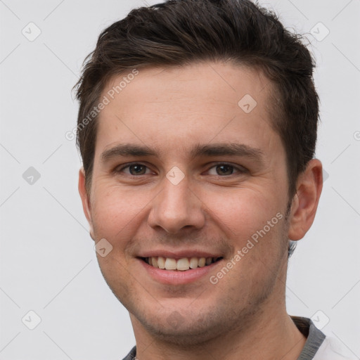 Joyful white young-adult male with short  brown hair and grey eyes