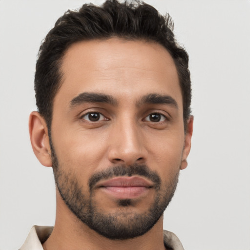 Joyful latino young-adult male with short  brown hair and brown eyes