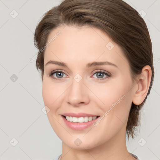 Joyful white young-adult female with medium  brown hair and grey eyes