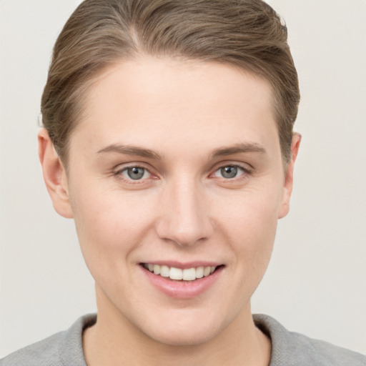 Joyful white young-adult female with short  brown hair and grey eyes