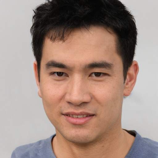 Joyful asian young-adult male with short  black hair and brown eyes