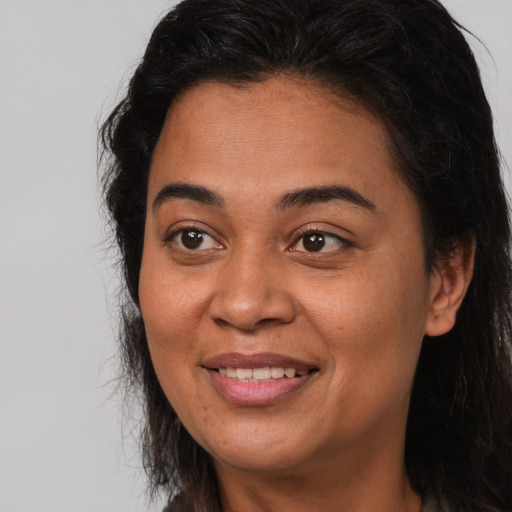 Joyful latino adult female with long  brown hair and brown eyes