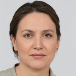 Joyful white adult female with medium  brown hair and grey eyes