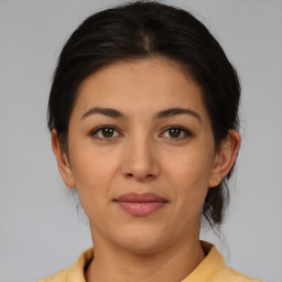 Joyful latino young-adult female with medium  brown hair and brown eyes