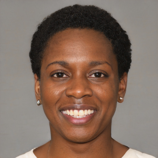 Joyful black young-adult female with short  black hair and brown eyes