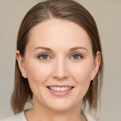 Joyful white young-adult female with medium  brown hair and grey eyes