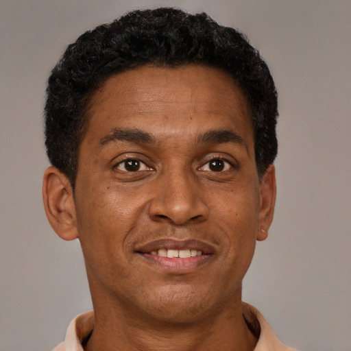Joyful black adult male with short  brown hair and brown eyes
