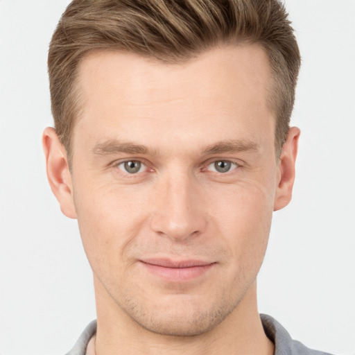 Joyful white young-adult male with short  brown hair and grey eyes