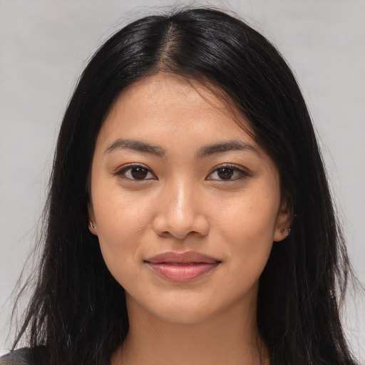 Joyful latino young-adult female with long  brown hair and brown eyes