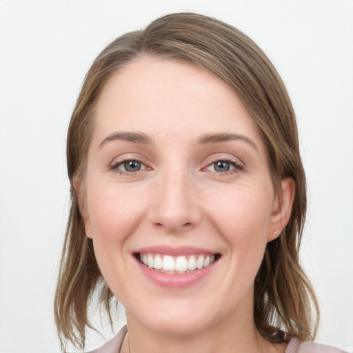 Joyful white young-adult female with medium  brown hair and blue eyes