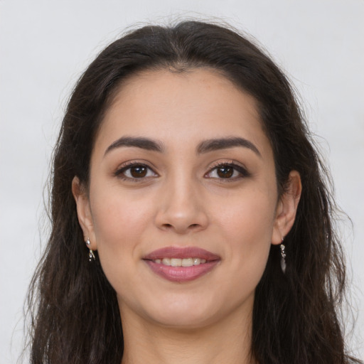 Joyful latino young-adult female with long  brown hair and brown eyes