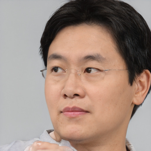 Joyful asian adult male with short  brown hair and brown eyes